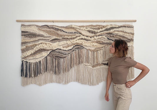 Artisanal fabric relief piece featuring undulating forms and slow-crafted fiber techniques.