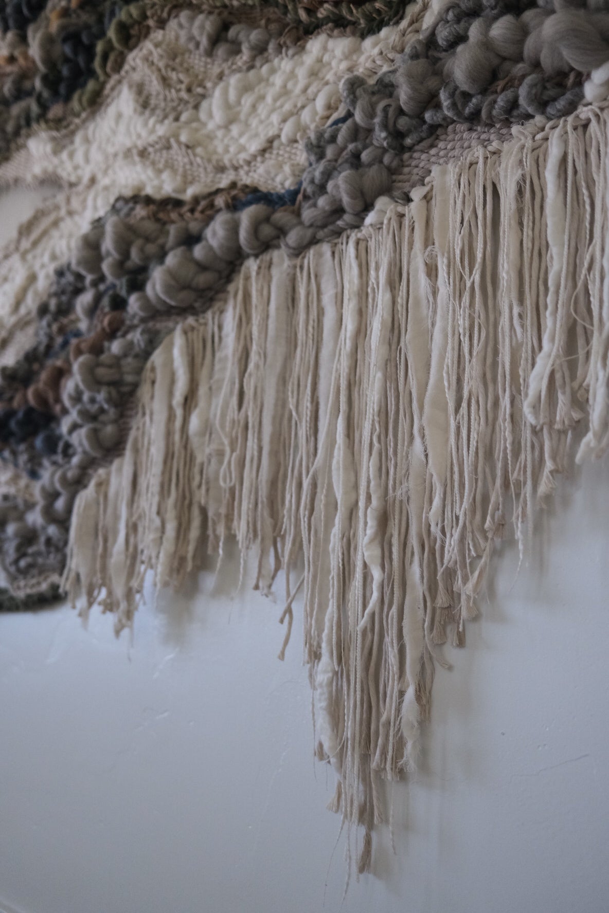 Large-scale woven wall art with undulating forms and natural fibers, designed by textile artist Rebecca Whitaker.