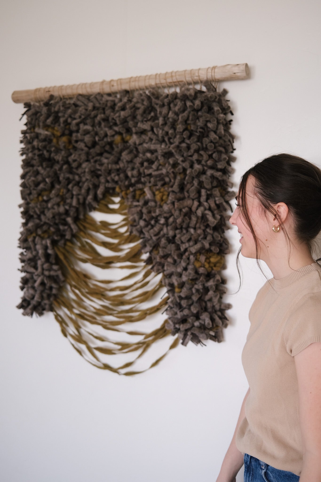 Neutral wall hanging featuring sculptural fiber techniques and a grounded, organic color palette.