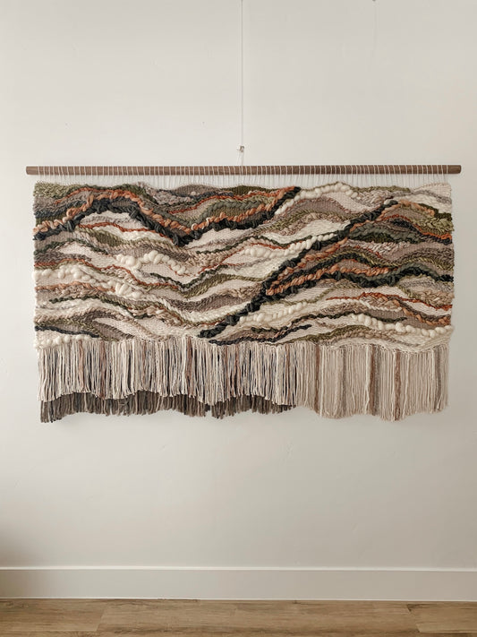 Soft fiber installation in muted tones, highlighting layered weaves and handcrafted movement.
