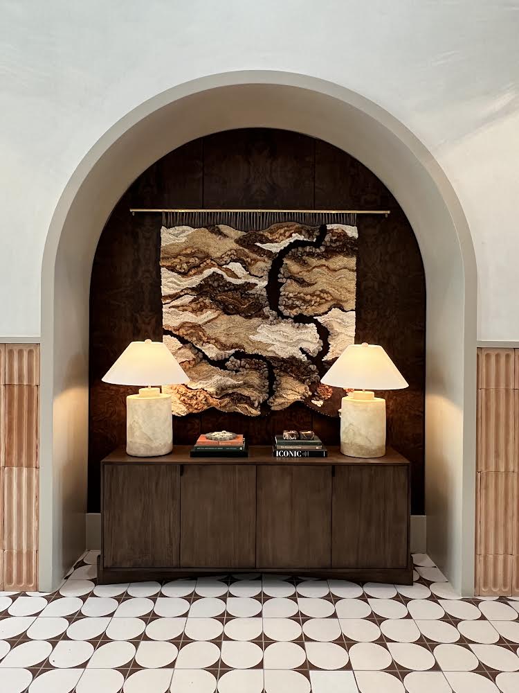 Neutral woven tapestry with organic wave-like patterns and rich texture, made from sustainable natural materials.