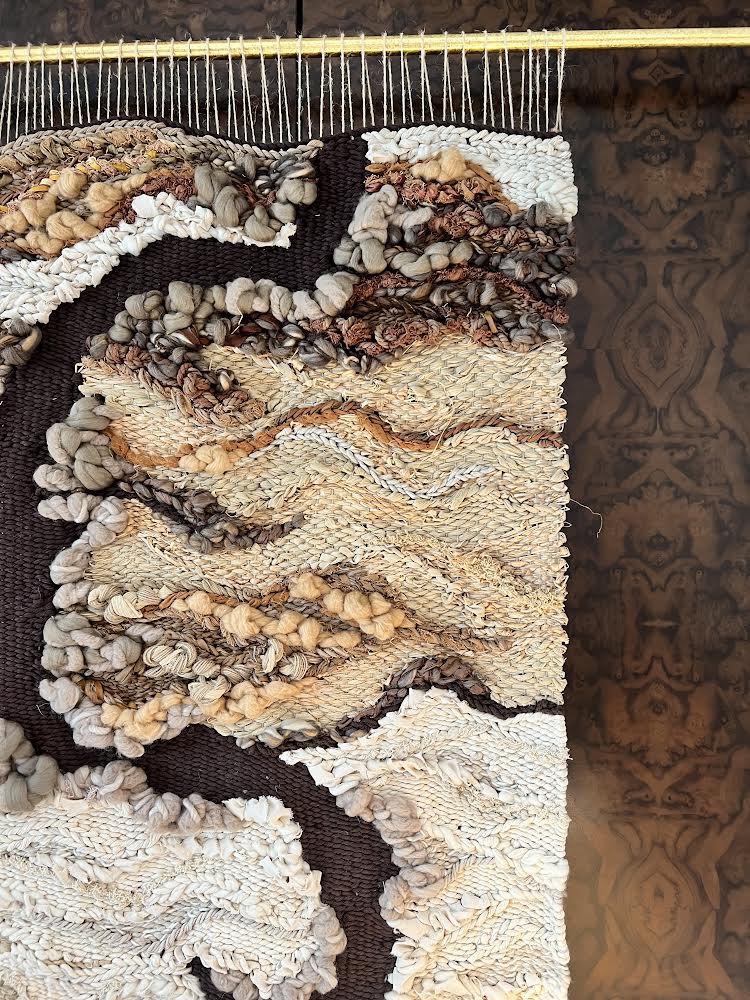 Neutral woven tapestry with organic wave-like patterns and rich texture, made from sustainable natural materials. Organic texture with colors in brown, burnt orange, ochre, beige, buff, camel, ivory and more earth tones.