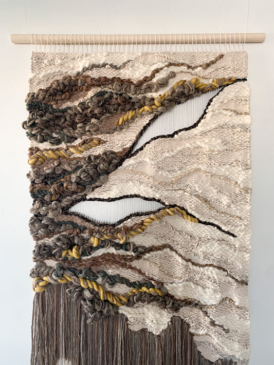 Wool and cotton art piece woven into an abstract landscape-inspired design with rich tactile contrast.
Negative space with open threads. Knotted and twisting yarn.