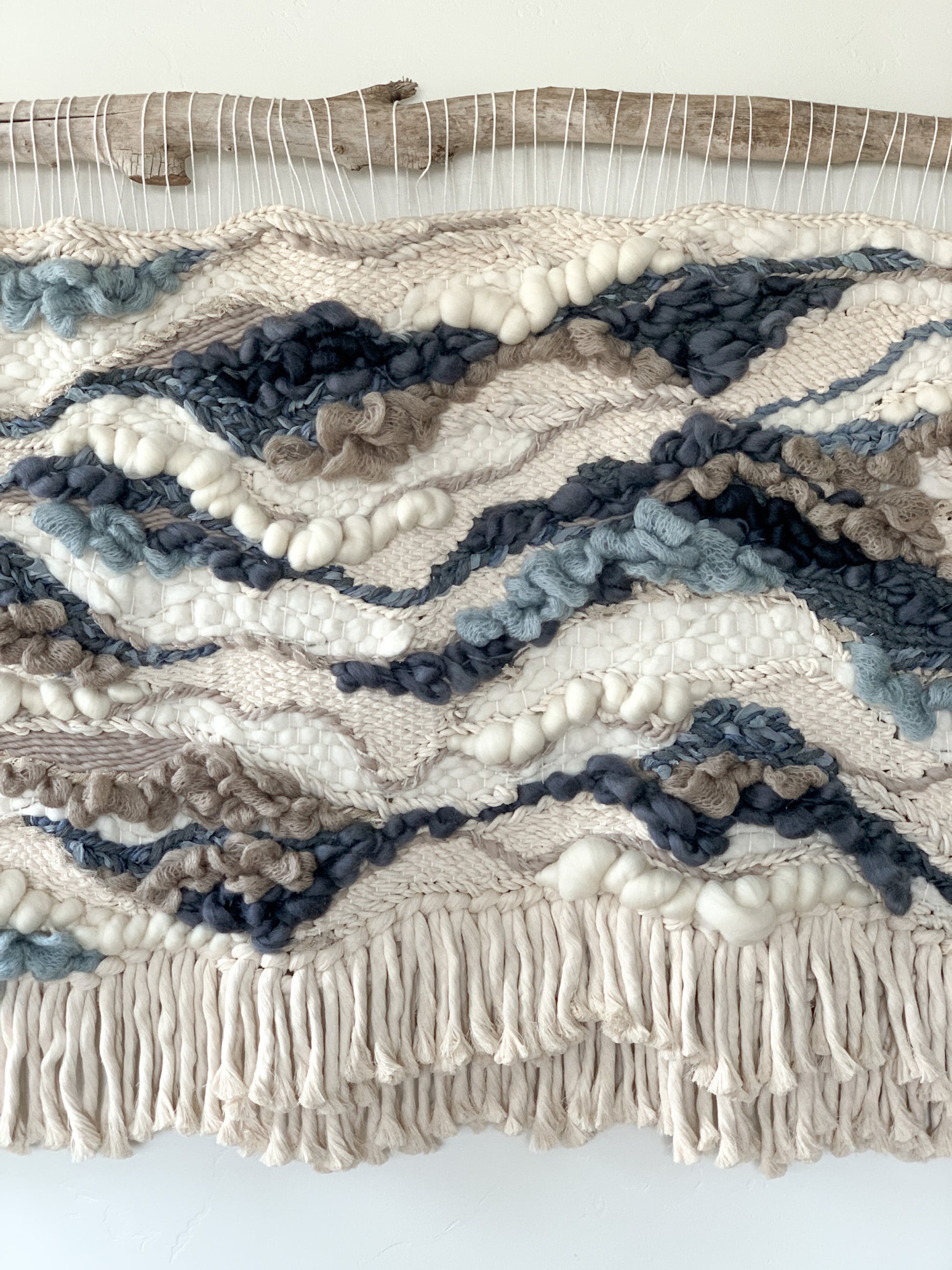 Architectural fiber art installation combining earthy threads and bold topographic motifs.
Lush fringe with bubbly texture and flow motion.