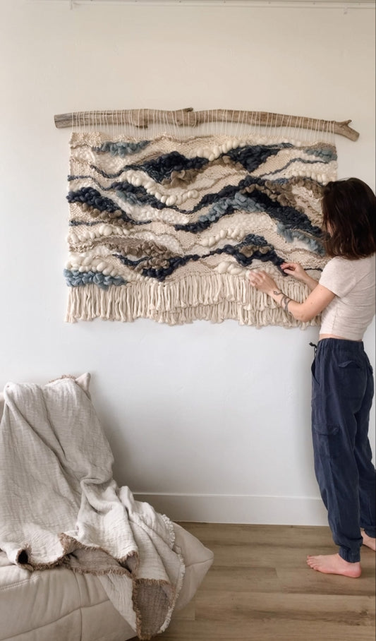 Architectural fiber art installation combining earthy threads and bold topographic motifs.