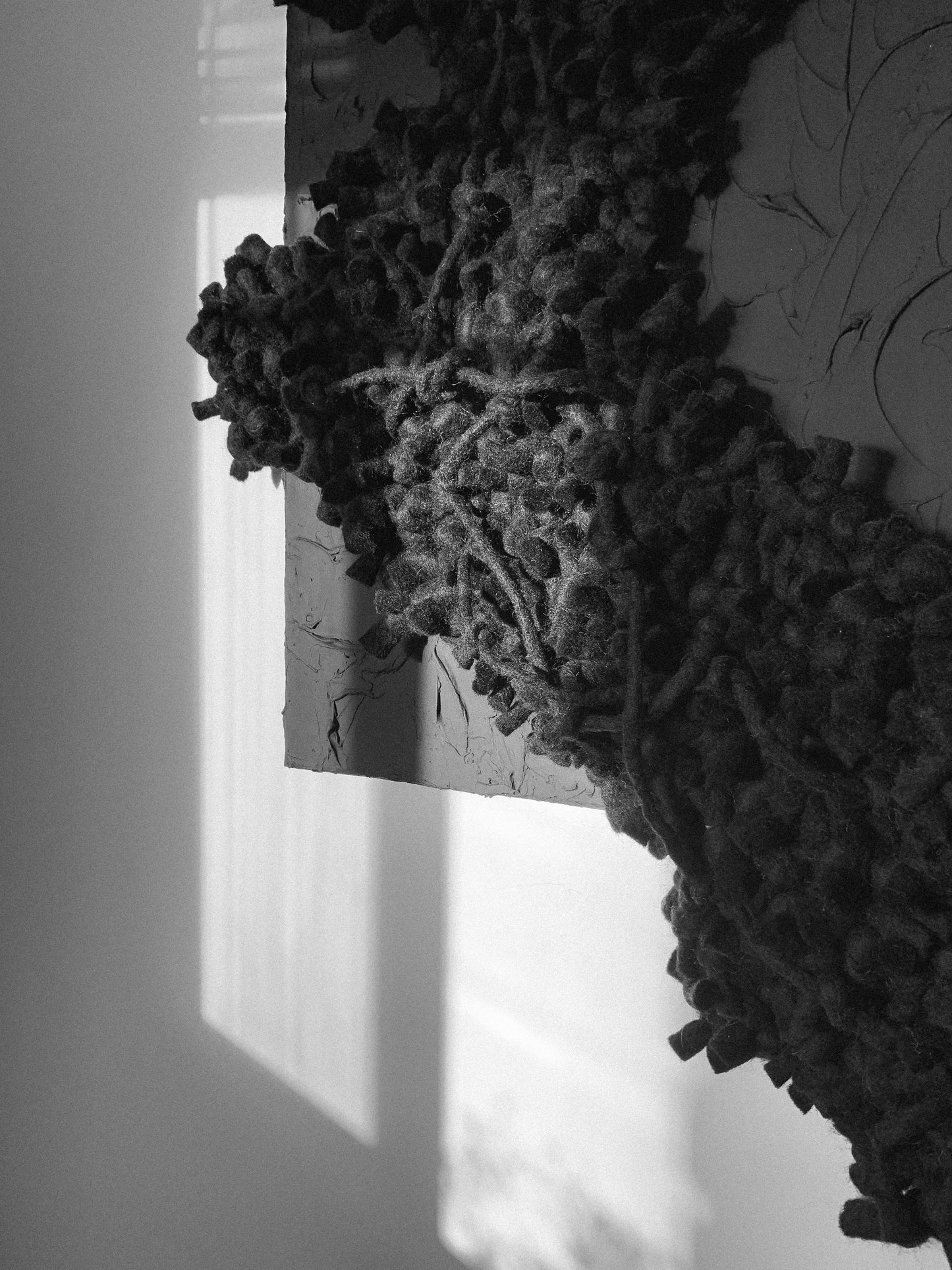 Contemporary textile wall art with bold textures, enhancing modern interiors. Accent color in black. Plaster and acrylic background. Mixed media art.