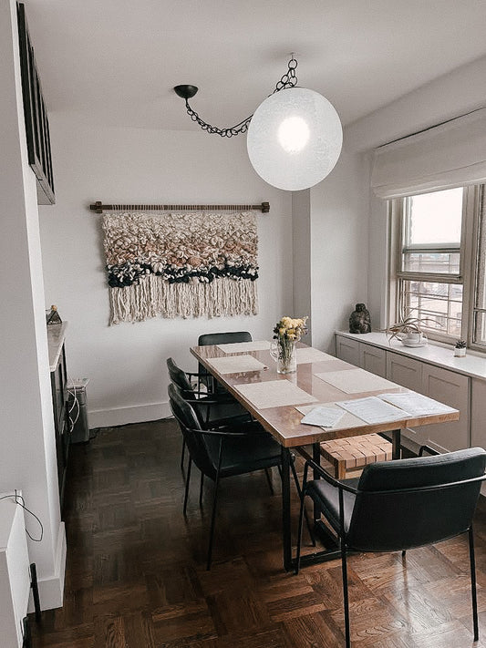 Handcrafted woven tapestry with intricate knotting techniques, creating a dynamic visual centerpiece. Accent colors in blue, beige, sand and other earthy tones.