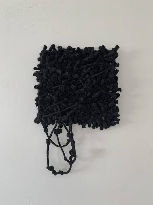 Modern woven wall hanging with asymmetrical design, blending various fiber textures for a unique aesthetic.