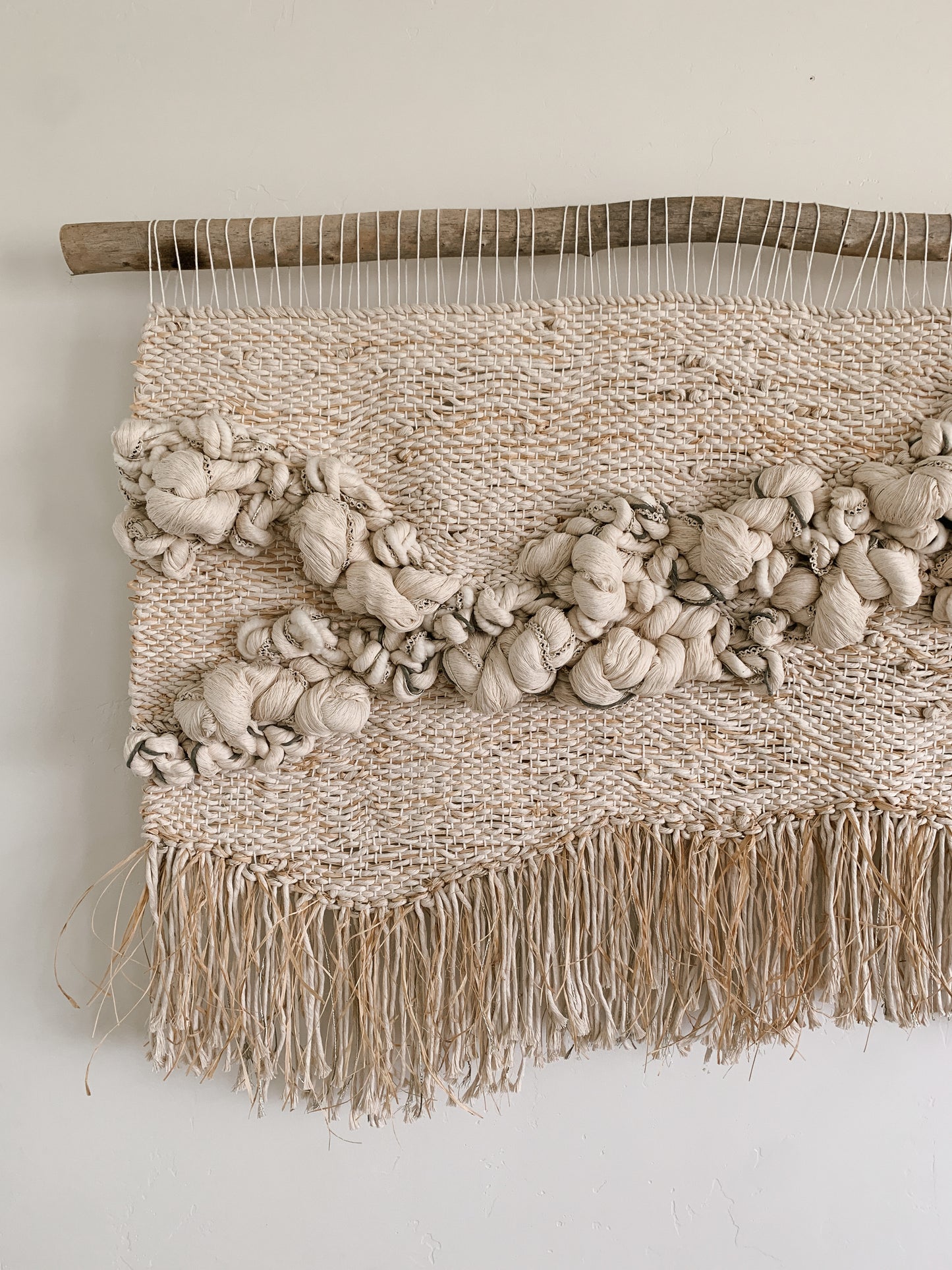 Statement woven wall piece featuring smooth curves and layered fiber work in a calm, monochromatic palette.