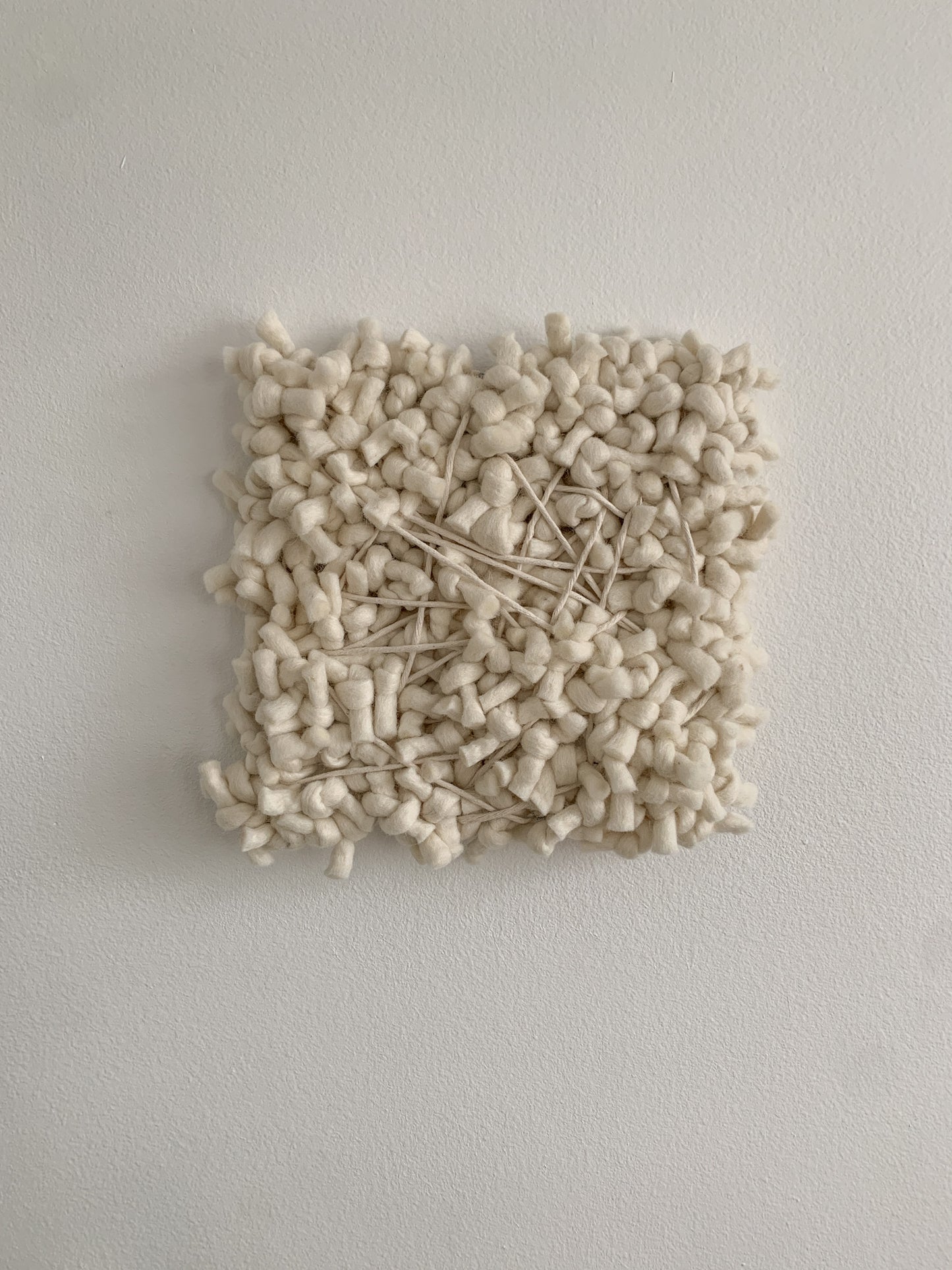 Contemporary fiber expression made with eco-conscious materials and intuitive patterning.
Accent color in beige with crossing threads and knotted face.