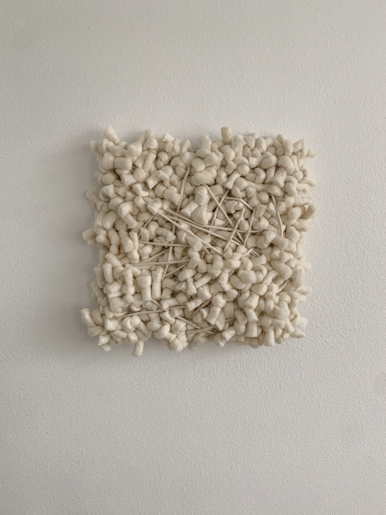 Contemporary fiber expression made with eco-conscious materials and intuitive patterning.
Accent color in beige with crossing threads and knotted face.