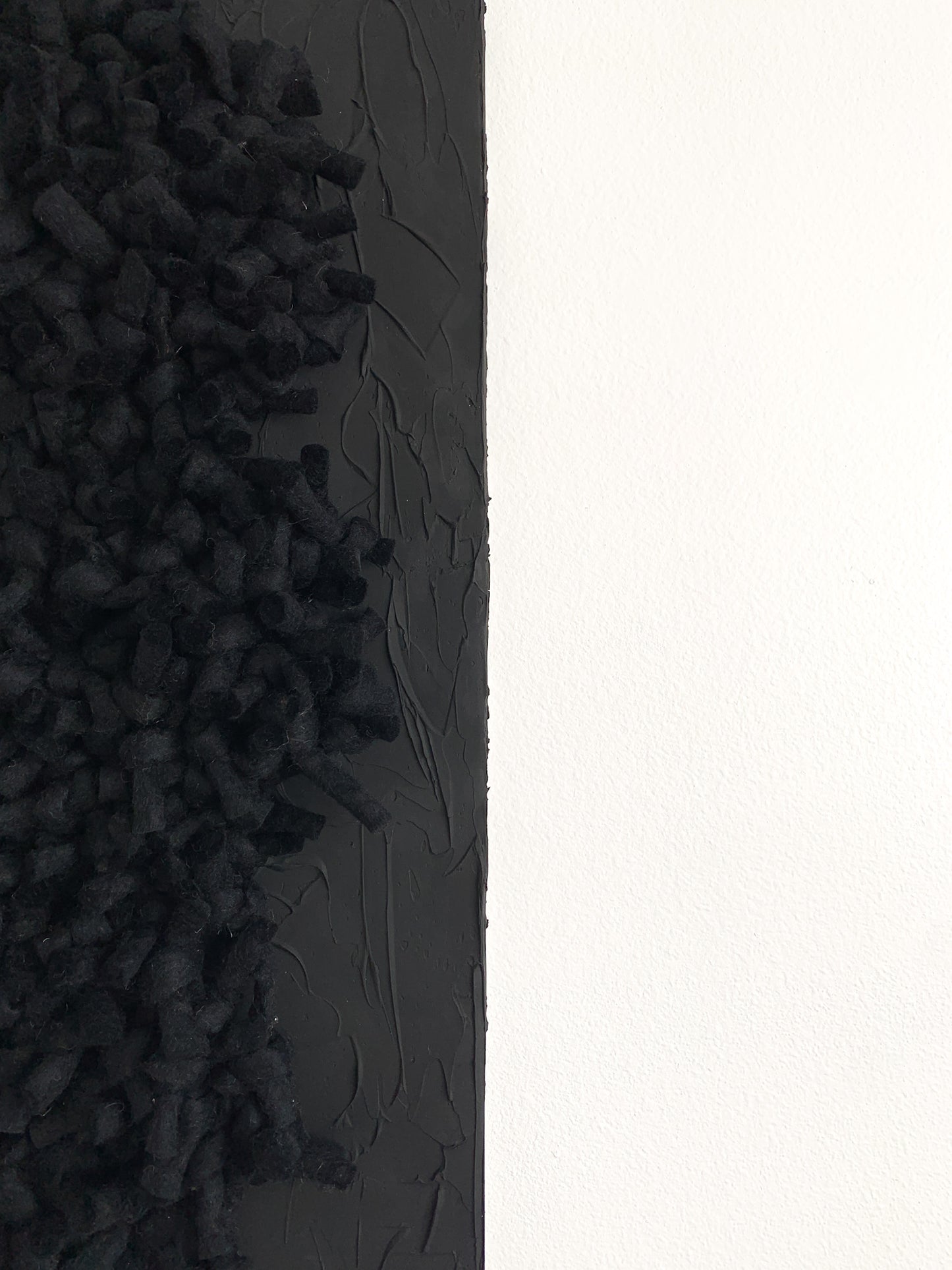 Handwoven black abstract wall piece with rich, tonal textures and dimensional fiberwork, blending wool and cotton in an intimate, sculptural composition.