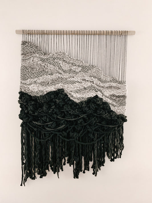 Textile sculpture composed of hand-dyed threads and natural fibers, showcasing organic flow and dimension. Accent color in gray, ivory and black.