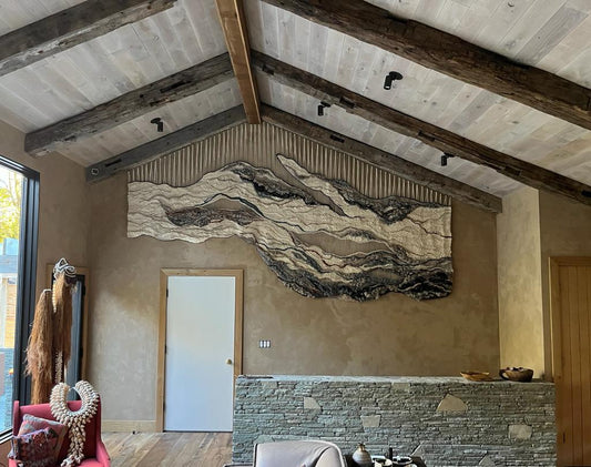 One-of-a-kind wall tapestry made from sustainable fibers, showcasing abstract organic shapes in beige, sand tones, grays and blues.