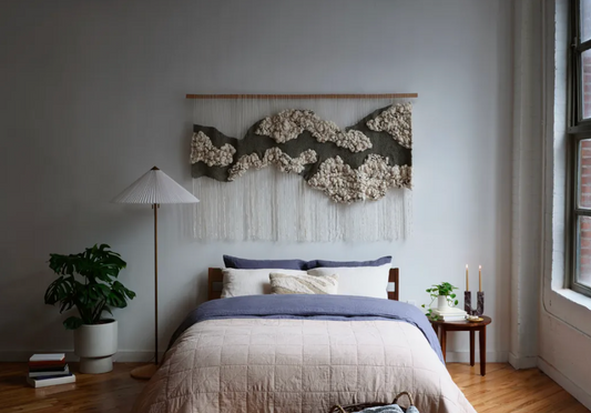 Tactile wall artwork made from plant-based fibers, reflecting a grounded and elemental visual story. Knotted texture with loose fringe.