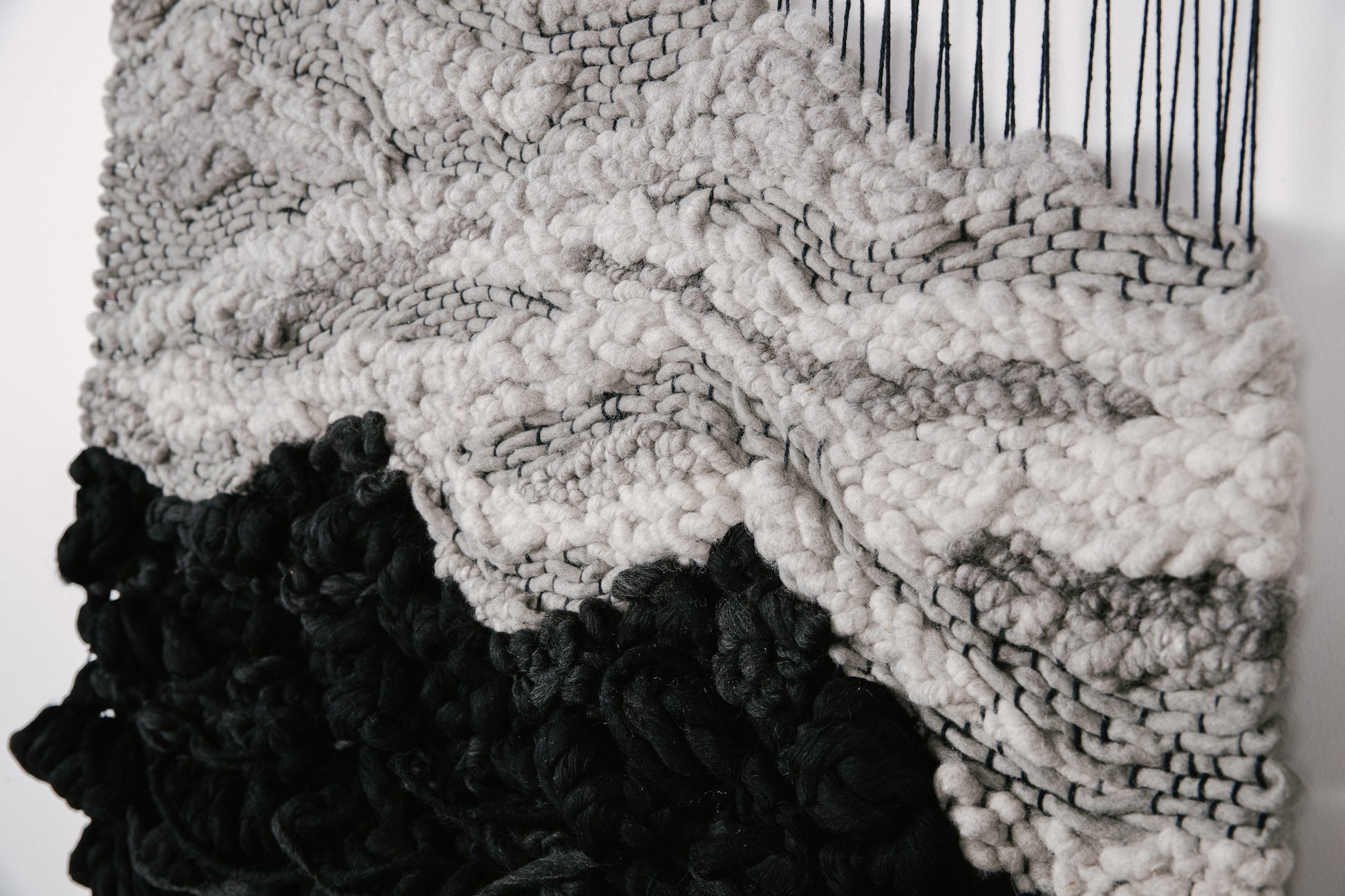 Textile sculpture composed of hand-dyed threads and natural fibers, showcasing organic flow and dimension. Resembling gravity and contrast.