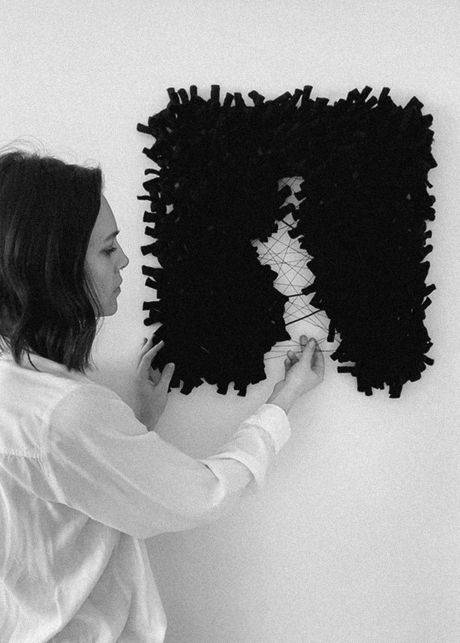 Handcrafted wall hanging with intricate interknot techniques, creating depth and movement in the design. Organic tear, with delicate threads. Accent in black.